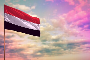 Fluttering Yemen flag mockup with the space for your content on colorful cloudy sky background. - obrazy, fototapety, plakaty