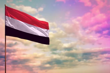 Foto op Plexiglas Fluttering Yemen flag mockup with the space for your content on colorful cloudy sky background. © Dancing Man