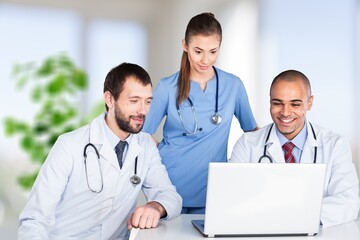 Doctor talking to an online patient on laptop screen sitting at clinic office, online consultation