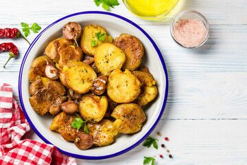 Vegan smashed baked potatoes with garlic sauce on wooden background. Top view, copy space.