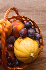 Vintage basket filled with various fruit on wooden table. Top view.