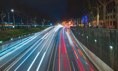 Fototapeta na wymiar Long exposure photo of traffic on the move with Car lights trail at dusk on the road - Lyon, France