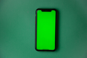 The phone with a green screen is on a green background. . High quality photo