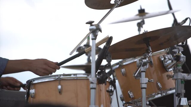 Drummer's hands playing on drums. Man is hitting drum cymbals in outdoor.   Music concept.