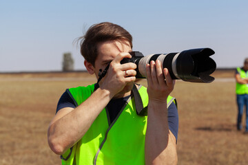 Man in yellow vest does plane spotting at the airport