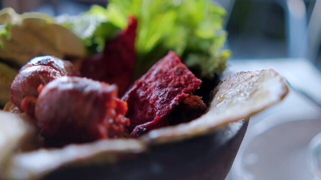 White cheese slices, lettuce, chorizo, and roasted nopales in Mexican molcajete