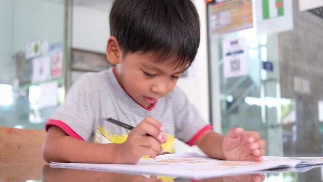 Asian little boy doing homework at home