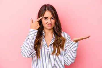 Young caucasian woman isolated on pink background showing a disappointment gesture with forefinger.