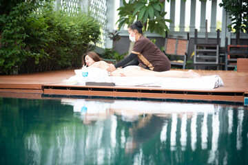 Asian beauty girls enjoy a massage by the resort's pool. Beauty treatment concept.