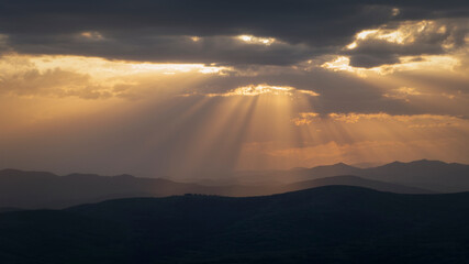 sunbeams with clouds and curved hills