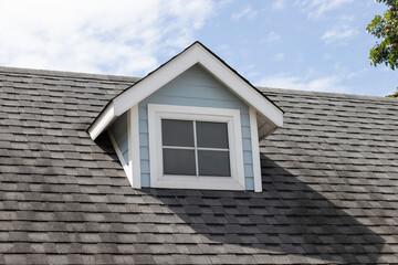 garret house and roof shingle on top of the house. dark asphalt tiles on the roof background.