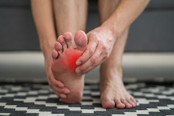 Foot pain, man suffering from feet ache at home