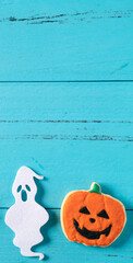 Top view of Halloween festive decorated icing sugar cookies on blue background.