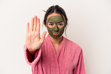 Young caucasian woman wearing a facial mask isolated on white background standing with outstretched hand showing stop sign, preventing you.