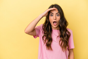 Fototapeta premium Young caucasian woman isolated on yellow background shouts loud, keeps eyes opened and hands tense.