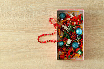 Fototapeta na wymiar Gift box with various Christmas toys on a wooden background for copying text