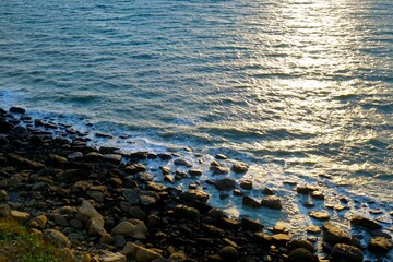 Waves lit up at sunset on the stony coast, surf at Cap Gris-Nez, near Audinghen, Pas-de-Calais, Hauts-de-France, France