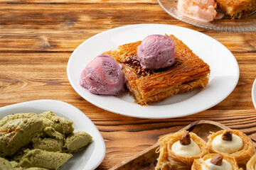 Turkish dessert kunefe served with ice cream on wooden background