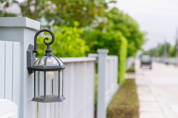 lamp light on the wall. Vintage iron lantern on the wall outdoor. Garden metal electrical lamp in a...