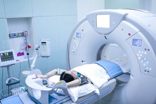 Patients screening on CT scanner. Man Undergoing CT Scan While Doctor's Using Computers. Examining man in CT scanner. Computer used tomography.