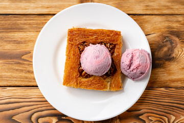 Turkish dessert kunefe served with ice cream on wooden background