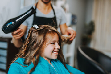 Beautiful hairstyle of cute girl in hair salon.