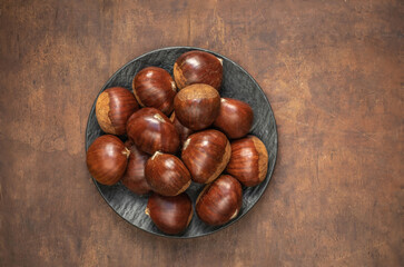 Chestnuts on on an old board with copy space. Autumn mood.  Horse chestnuts top view