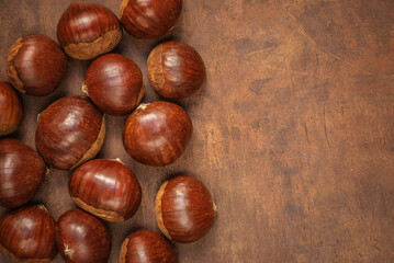 Chestnuts on on an old board with copy space. Autumn fall concept. Horse chestnuts top view.