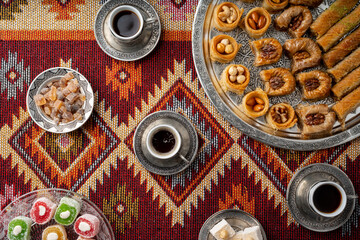 Turkish coffee and sweets served on colorful patterned carpet