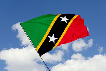 Saint Kitts and Nevis flag isolated on the blue sky background. close up waving flag of Saint Kitts and Nevis. flag symbols of Saint Kitts and Nevis. Concept of Saint Kitts and Nevis.