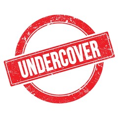 UNDERCOVER text on red grungy round stamp.