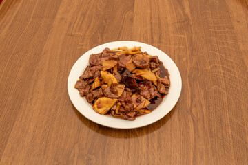 Chinese restaurant popular recipe with beef with bamboo and mushrooms, oyster and soy sauce on white plate