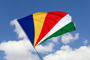 Seychelles flag isolated on the blue sky background. close up waving flag of Seychelles. flag symbols of Seychelles. Concept of Seychelles.