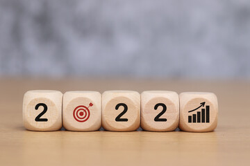 Wooden cube with 2022 goal icon, concept to success of growing business.