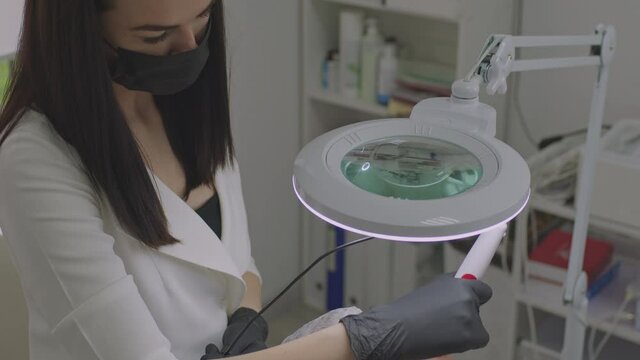 The beautician takes care of the patient's skin with a microinjection procedure.