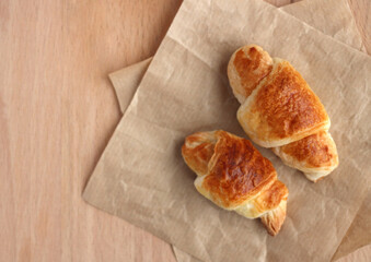 small croissants with apple on a wooden board, top view