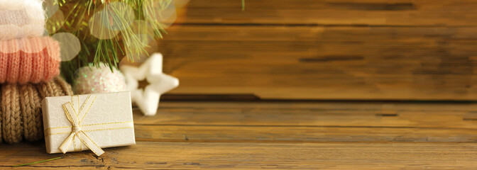 happy new year banner, gift in white box on wooden background next to christmas toys and spruce branch