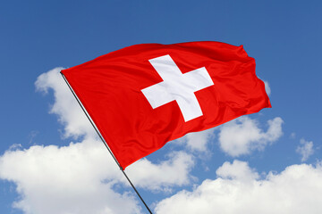 Switzerland flag isolated on the blue sky background. close up waving flag of Switzerland. flag...