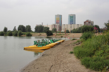 Russia, Novosibirsk 09.08.2021: catamaran boats for tourists walking on the beach by the water in summer