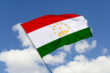 Tajikistan flag isolated on the blue sky background. close up waving flag of Tajikistan. flag symbols of Tajikistan. Concept of Tajikistan.