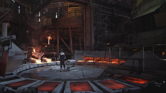 View inside a copper production plant, a worker in a copper bottling workshop, pouring molten copper into molds. (metallurgical plant in china)