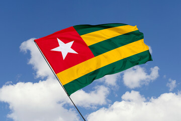 Togo flag isolated on the blue sky background. close up waving flag of Togo. flag symbols of Togo. Concept of Togo.