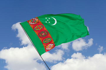 Turkmenistan flag isolated on the blue sky background. close up waving flag of Turkmenistan. flag symbols of Turkmenistan. Concept of Turkmenistan.