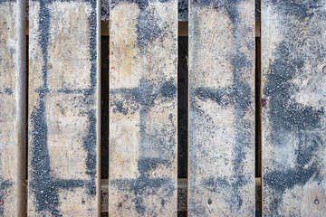 A pallet from paving slabs covered with concrete chips. Background of wood planks with fine concrete chips.