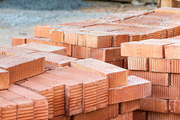 Red ceramic bricks stacked on a construction site. Construction Materials. Red brick for building a house.