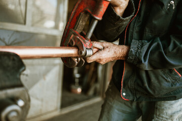 Traditional coppersmith workshop for copper brewing pots manufacturing. This handmade brewery kettles will be used for making traditional alcohol brandy drinks. Small traditional business concept.