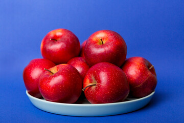 juicy red apples in a bowl or plate on the table top view. Copy space