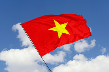 Naklejka premium Vietnam flag isolated on the blue sky background. close up waving flag of Vietnam. flag symbols of Vietnam. Concept of Vietnam.