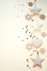 A composition of Christmas textile and wooden ornaments, confetti. Vertical location. For the blog. New Year. Space for text. Beige background.