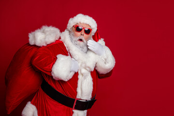 Photo of excited crazy retired man carry big bag gifts wow reaction wear santa hat costume isolated red color background